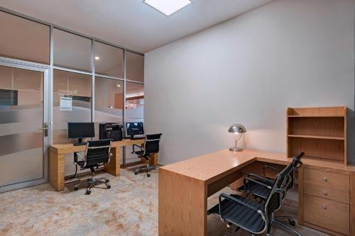 an office with two desks with chairs and a computer at Four Points by Sheraton Cancun Centro in Cancún