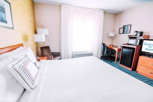 a hotel room with a large bed and a desk at Fairfield by Marriott Medford Long Island in Medford