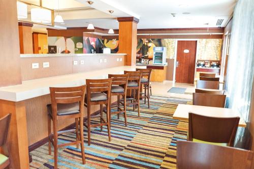 a restaurant with a row of chairs and a bar at Fairfield by Marriott Medford Long Island in Medford