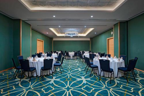 a banquet room with tables and chairs and a room with green walls at Four Points by Sheraton Cancun Centro in Cancún