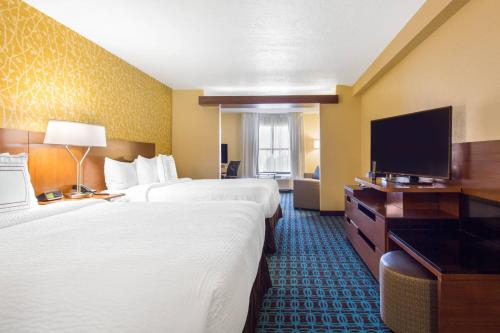 a hotel room with two beds and a flat screen tv at Fairfield Inn & Suites by Marriott Santa Fe in Santa Fe