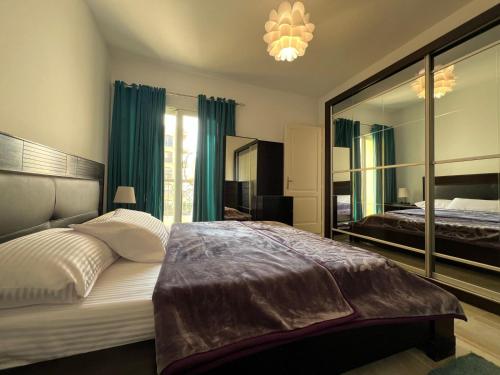 ein Schlafzimmer mit einem großen Bett und einem großen Spiegel in der Unterkunft 2 bedroom apartment in rehab cityy in Burg el-Ḥudûd