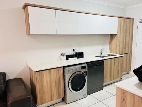 a kitchen with a washing machine and a sink at The Blyde in Pretoria