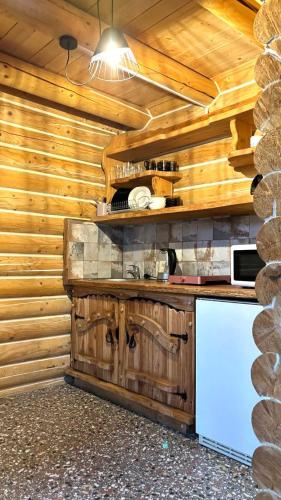a kitchen with wooden walls and a counter with a refrigerator at Oberig Apartmens in Vorokhta