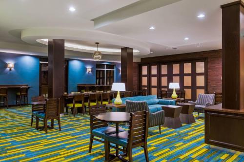 a lobby with a blue couch and tables and chairs at Fairfield Inn & Suites Riverside Corona/Norco in Norco