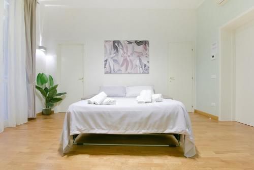 a white bedroom with a bed with white sheets at SUPER CENTRAL - Antique flat in Bologna