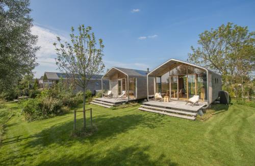 a tiny house in a garden with a yard at Lakehouses luxe family holiday house 6 pers in Oud-Ade
