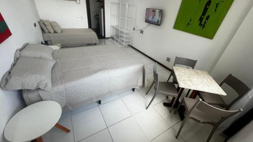 a small room with a bed and a table at Sol Victoria Marina flat 804 PC imoveis in Salvador