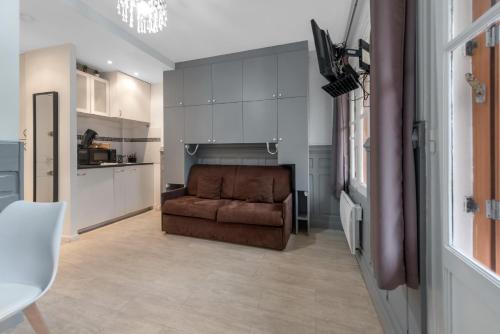 un salon avec un canapé marron et une cuisine dans l'établissement Studio 100M de la plage & casino, à Villers-sur-Mer