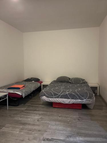 2 lits sont installés dans une pièce avec un mur dans l'établissement Logement type studio 1 piece proche zénith, à Strasbourg