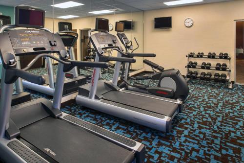 a gym with several tread machines and a clock at Fairfield Inn & Suites by Marriott New Castle in New Castle