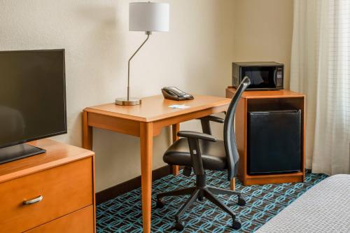 a hotel room with a desk with a computer and a chair at Fairfield by Marriott Peoria East in Peoria