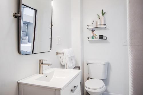 a white bathroom with a sink and a mirror at Tiny Home for a King in Dayton