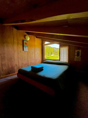 a bedroom with a bed in a wooden room at Hostal Las Natalias in Futaleufú