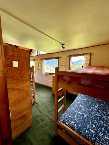 a bedroom with two bunk beds and a window at Hostal Las Natalias in Futaleufú