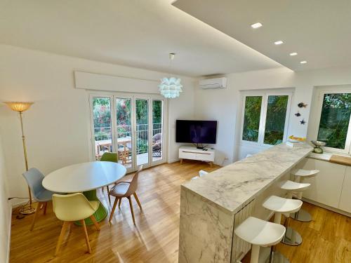 a kitchen and living room with a table and chairs at Botanic Garden Apartment Calandre Beach Ventimiglia in Ventimiglia