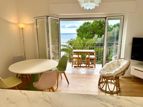a living room with a table and chairs and a balcony at Botanic Garden Apartment Calandre Beach Ventimiglia in Ventimiglia