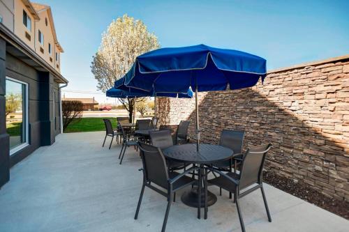 a group of tables and chairs with a blue umbrella at Fairfield Inn Joplin in Joplin