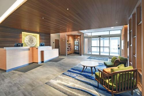an office lobby with a desk and chairs and a table at Fairfield by Marriott Inn & Suites Mansfield in Mansfield