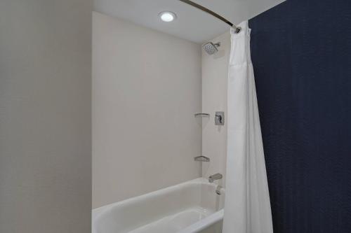 a bathroom with a tub and a shower curtain at Fairfield by Marriott Inn & Suites Mansfield in Mansfield