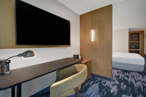 a hotel room with a desk with a television and a bed at Fairfield by Marriott Inn & Suites Mansfield in Mansfield