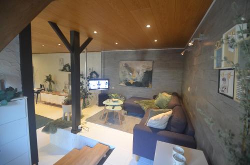 a living room with a couch and a cross on the wall at Sea-renity 23 met sauna en jacuzzi in Eggewaartskapelle