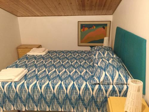 a bedroom with a bed with a blue and white comforter at Villa Letizia in San Lucido