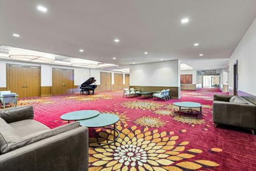 a large room with couches and tables and a piano at Chicago Marriott Naperville in Naperville