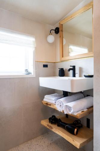 a bathroom with a sink and towels and a mirror at ONGA Boutique Lodge in Alta