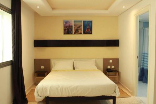 a bedroom with a bed with a black and white headboard at Le Parisien Tunis in Tunis