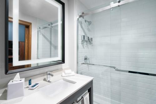 a white bathroom with a sink and a shower at Four Points by Sheraton Oklahoma City Airport in Oklahoma City