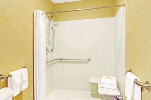 a bathroom with a shower and a toilet with towels at Days Inn by Wyndham Cherokee Near Casino in Cherokee