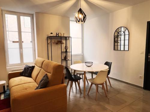un salon avec un canapé et une table dans l'établissement Agen hyper-centre avec garage securise, à Agen