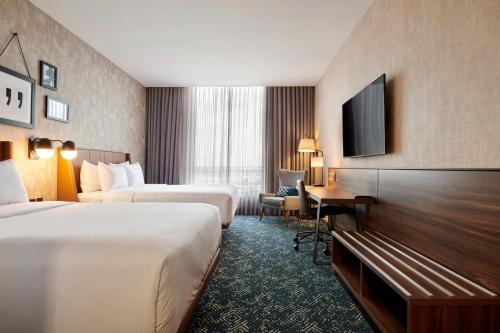 a hotel room with two beds and a television at Four Points by Sheraton Ciudad Juarez in Ciudad Juárez