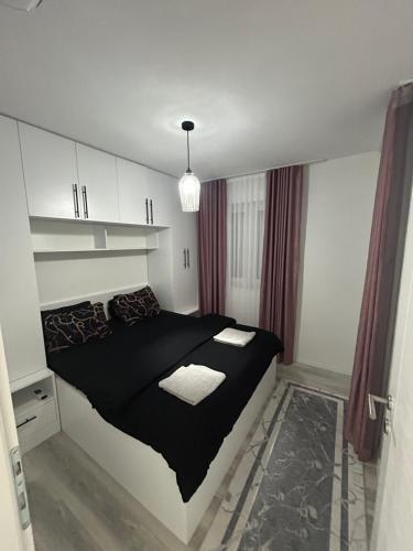 a bedroom with a black bed in a room at Sweet Holiday in Mostar