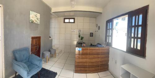 a bathroom with a blue chair in a room at Suítes Mar Azul in Aracaju