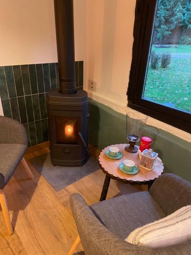 - un salon avec une cuisinière et une table à manger dans l'établissement la petite Normande, à Triqueville