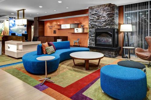a living room with a blue couch and a fireplace at Fairfield Inn & Suites by Marriott Lansing at Eastwood in Lansing