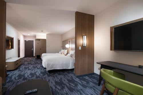a hotel room with a bed and a flat screen tv at Fairfield Inn & Suites by Marriott Tyler South in Tyler