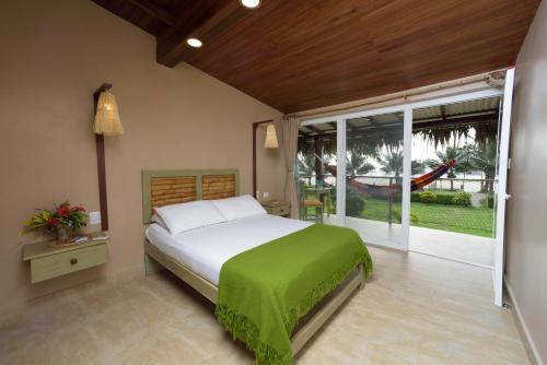 a bedroom with a bed and a large window at Hotel Kundalini in Montañita