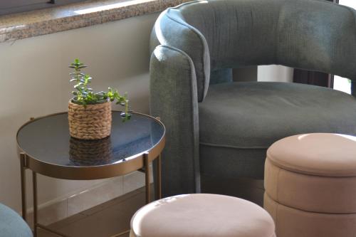 a chair and a table with a potted plant on it at Hotel Bel Sogno in Rimini