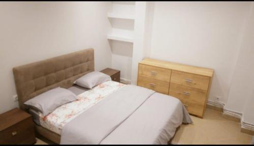 a bedroom with a bed and a wooden dresser at Appartement familial centre de Hydra in Hydra