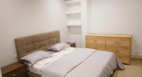 a bedroom with a bed and a wooden dresser at Appartement familial centre de Hydra in Hydra
