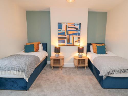 two beds in a room with two lamps on tables at 29 Garnet Street in Saltburn-by-the-Sea