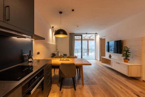a kitchen with a wooden table and a dining room at A-Lunis in Brunico