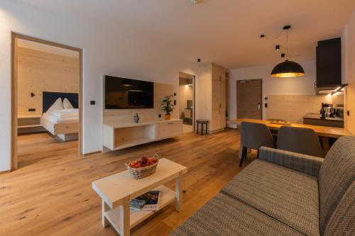 a living room with a couch and a room with a bed at A-Lunis in Brunico