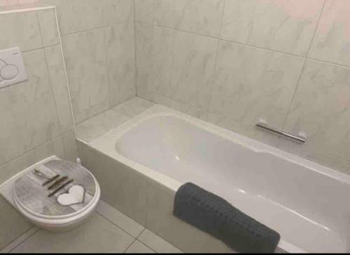 a white bathroom with a tub and a toilet at Comodo appartamento nel cuore dell'Engadina in Celerina
