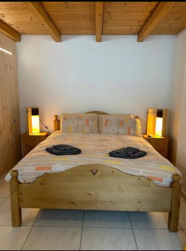 a bedroom with a wooden bed with two night stands at Comodo appartamento nel cuore dell'Engadina in Celerina