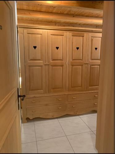 a wooden cabinet in a room with a tile floor at Comodo appartamento nel cuore dell'Engadina in Celerina