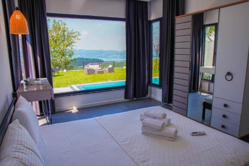 a bedroom with a bed and a large window with a pool at SAPANCA JOWA in Sapanca